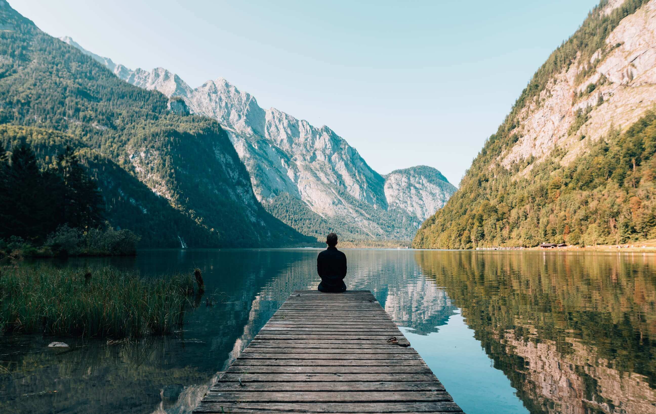 A man meditates in a calm mountain scenery
